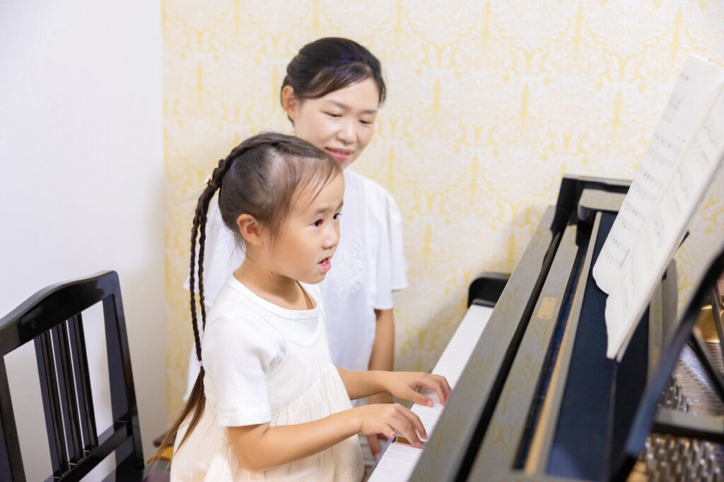 「３歳からのピアノコース」に通いピアノを弾いている女の子
